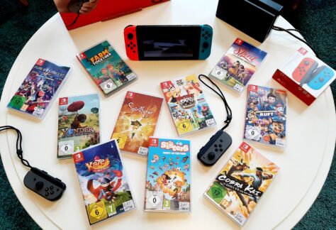 Auf einem Tisch liegen verschiedene Konsolenspiele für die Nintendo Switch Konsole sowie die passende Konsole.